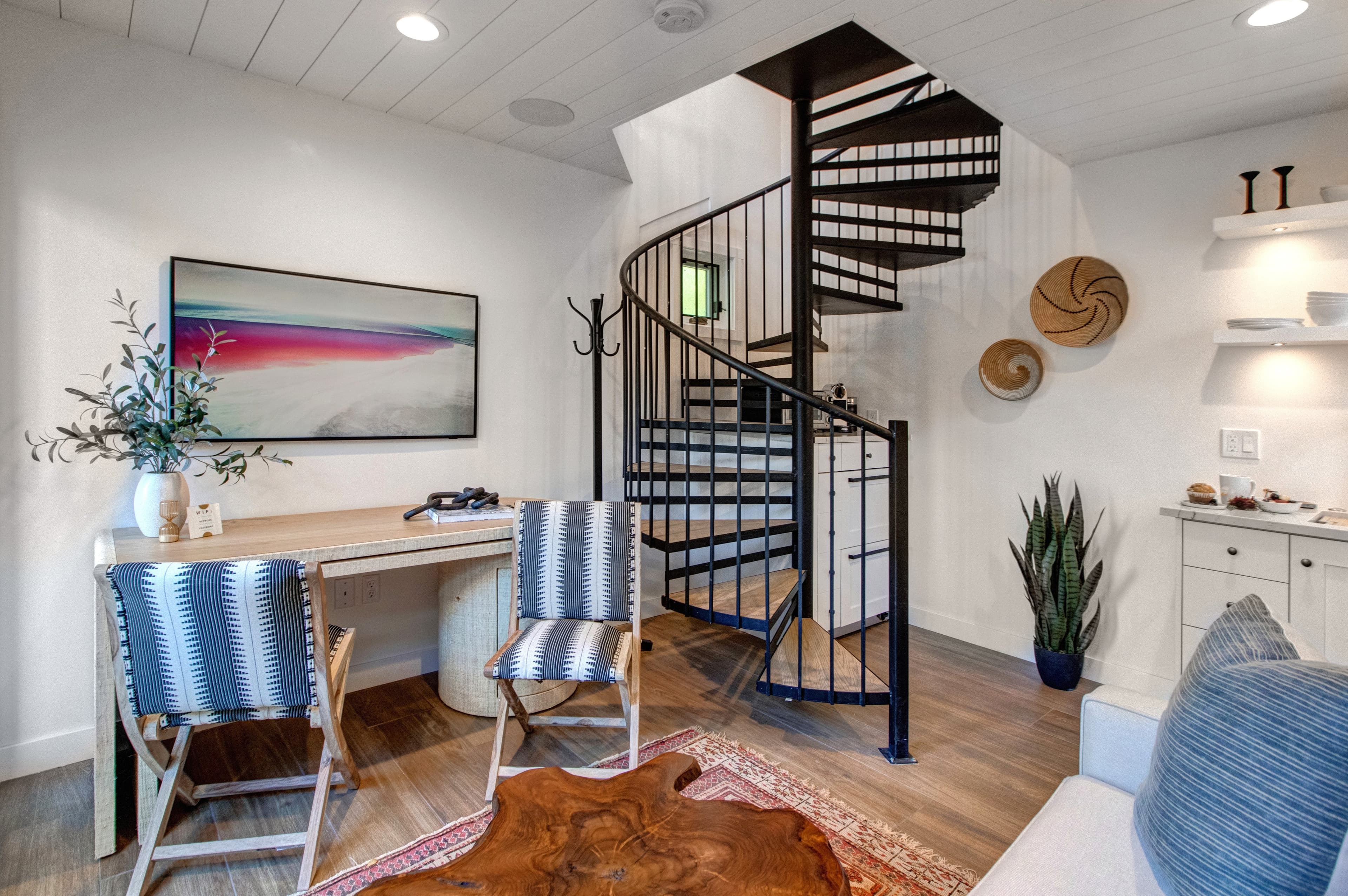 Detached guest suite accessed via the patio. Features a living area with a small kitchenette, TV, a desk and a queen sleeper sofa for additional guests.