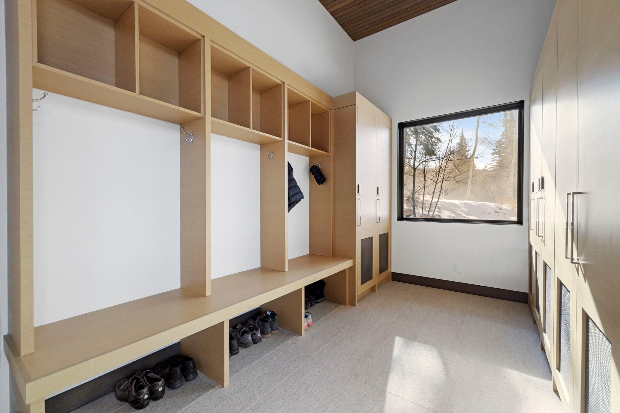 A view of a mudroom with storage for coats and shoes.
