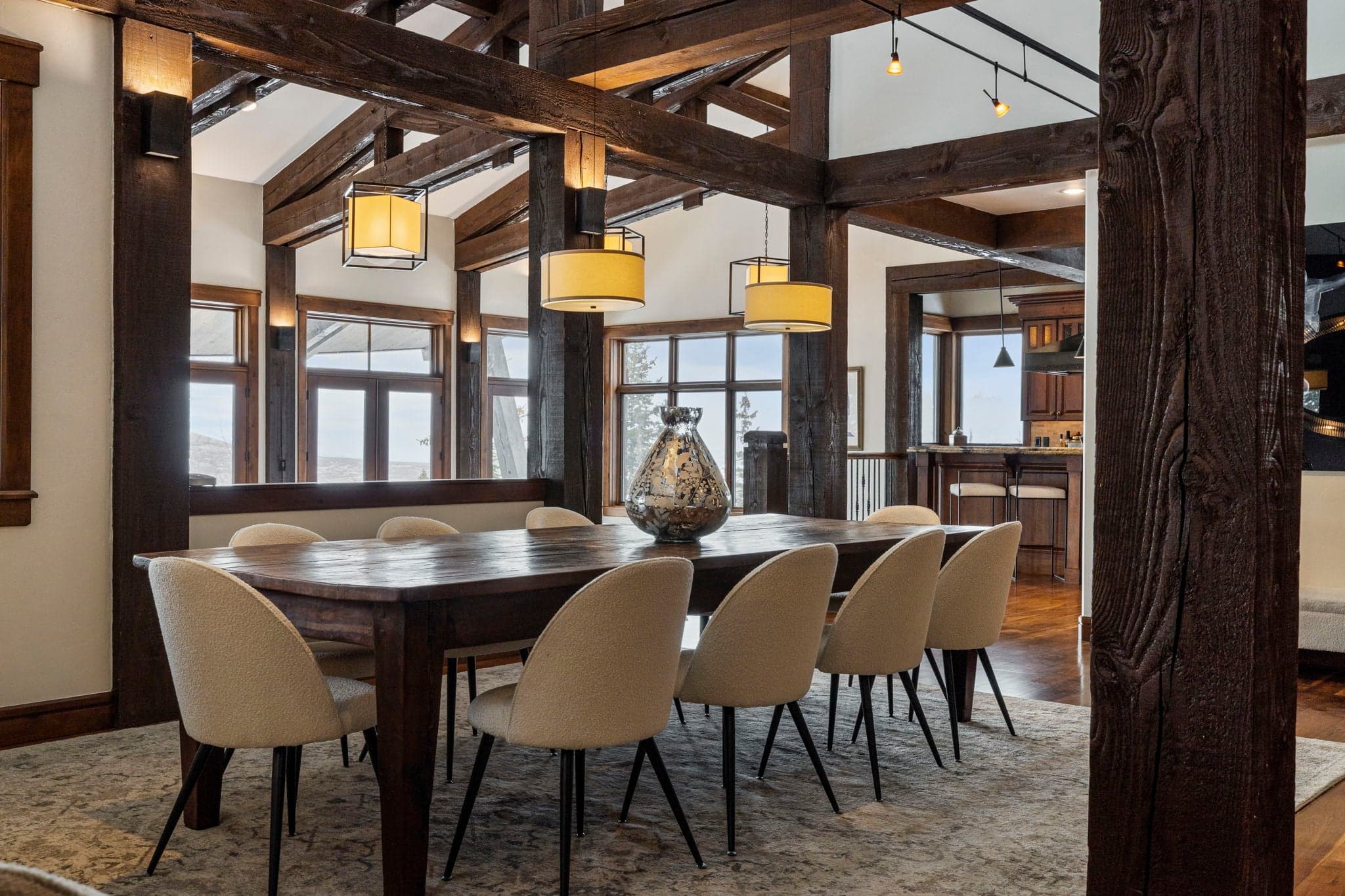a long dining table in an elegant dining room with mountain views
